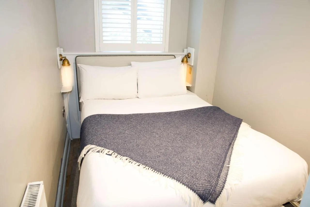 a bed in a small room with a window at Henrietta House, a member of Radisson Individuals in Bath