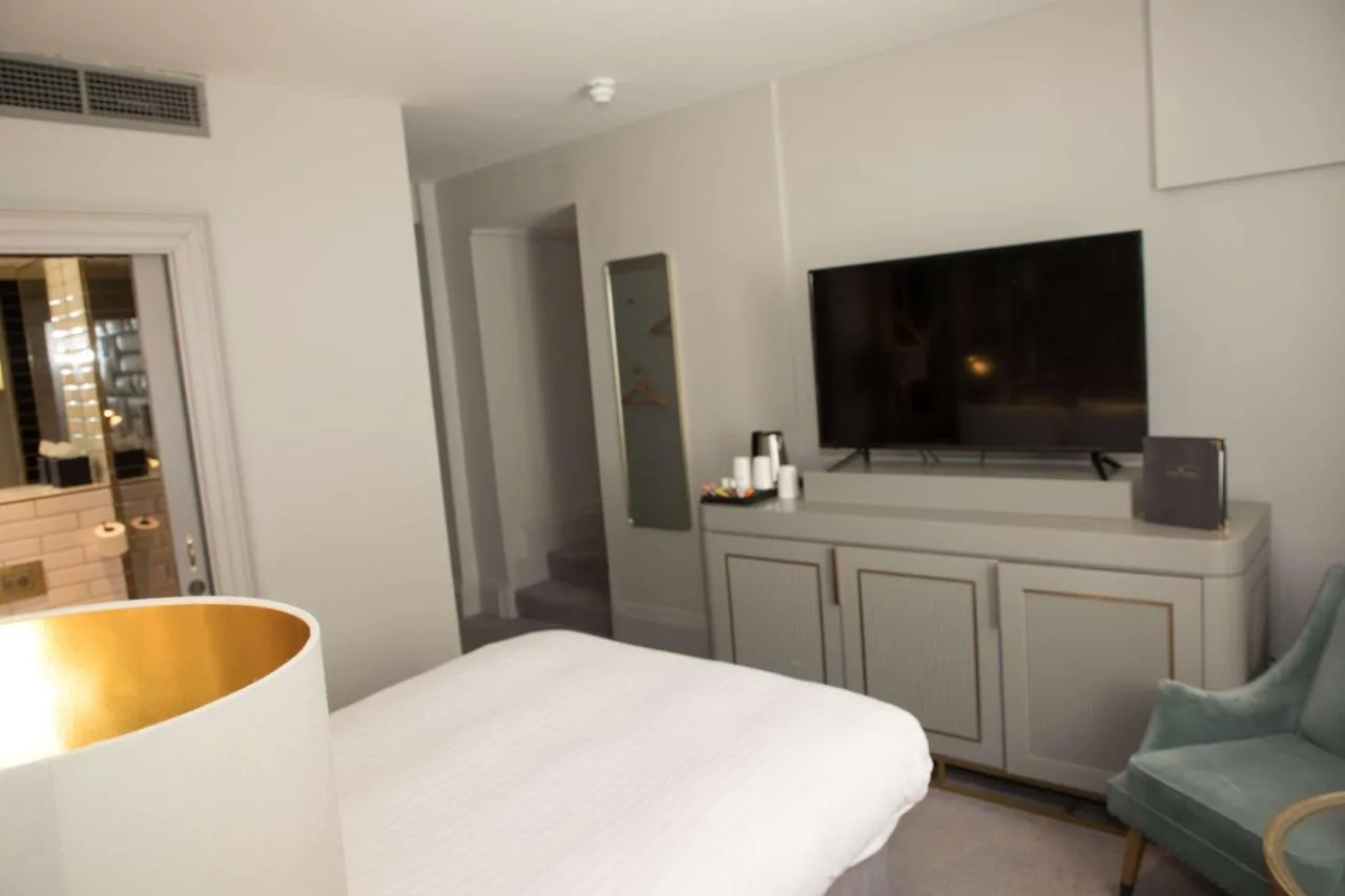 a room with a bed and a tv and a chair at Henrietta House, a member of Radisson Individuals in Bath