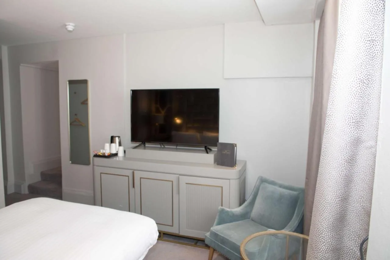 a bedroom with a bed and a tv and a chair at Henrietta House, a member of Radisson Individuals in Bath