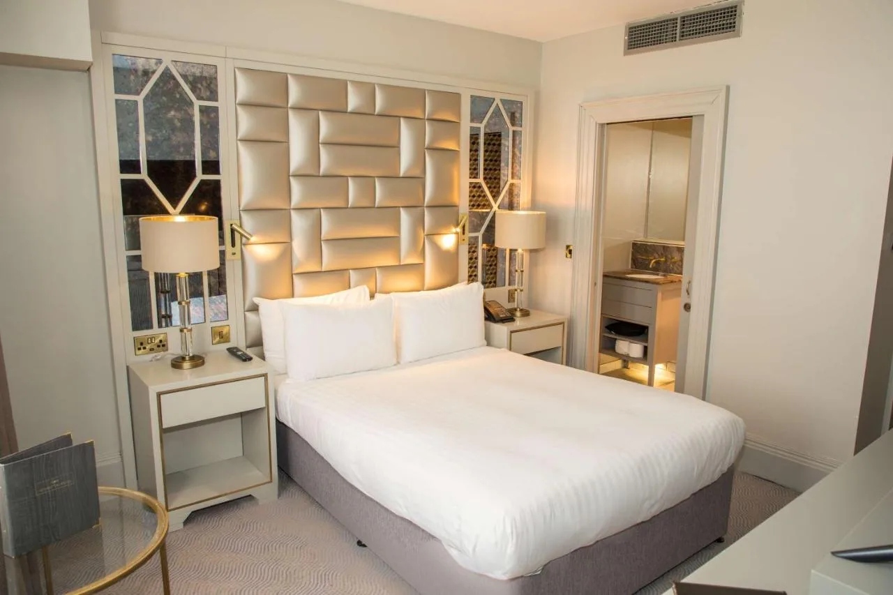 a bedroom with a large white bed and two tables at Henrietta House, a member of Radisson Individuals in Bath